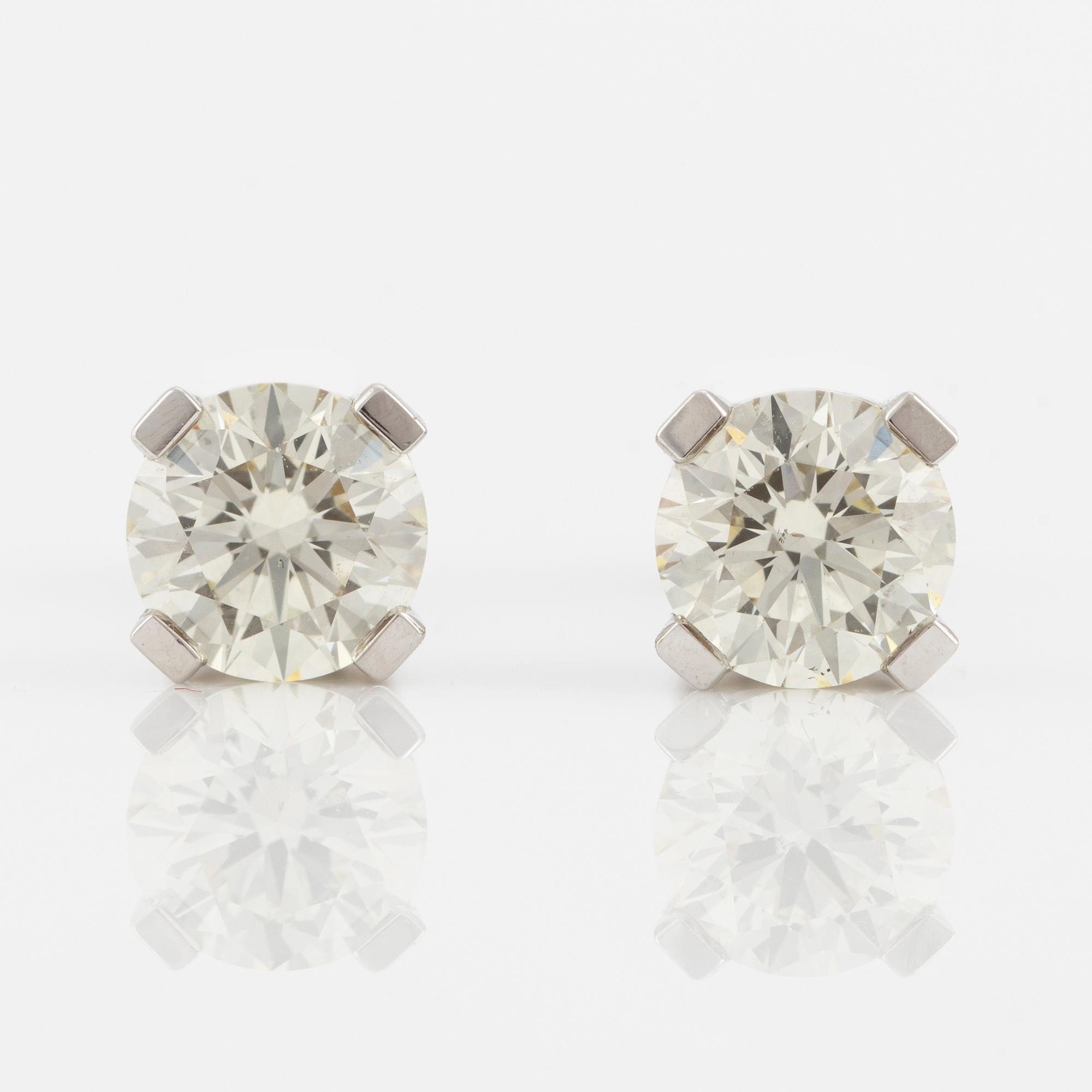 A pair of 18K gold earrings with round brilliant-cut diamonds.