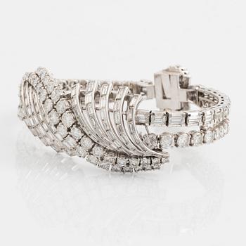 A platinum bracelet set with round brilliant- and baguette-cut diamonds.