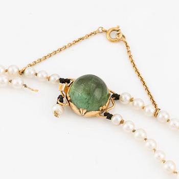 Pearl necklace, double-stranded with graduated cultured pearls, with an 18K gold clasp and cabochon-cut green tourmaline.