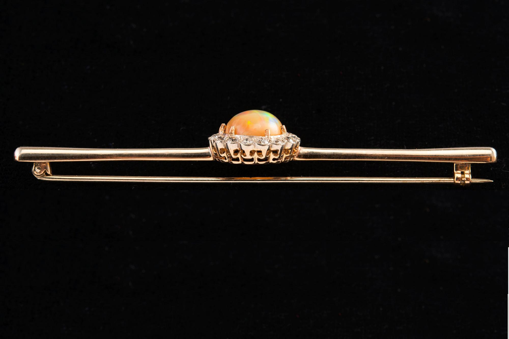 BROSCH, Briljantslipade diamanter ca 0.65 ct, Opal 10 mm.
14K guld. Ostämplad. Längd 85 mm, vikt 8,2 g.