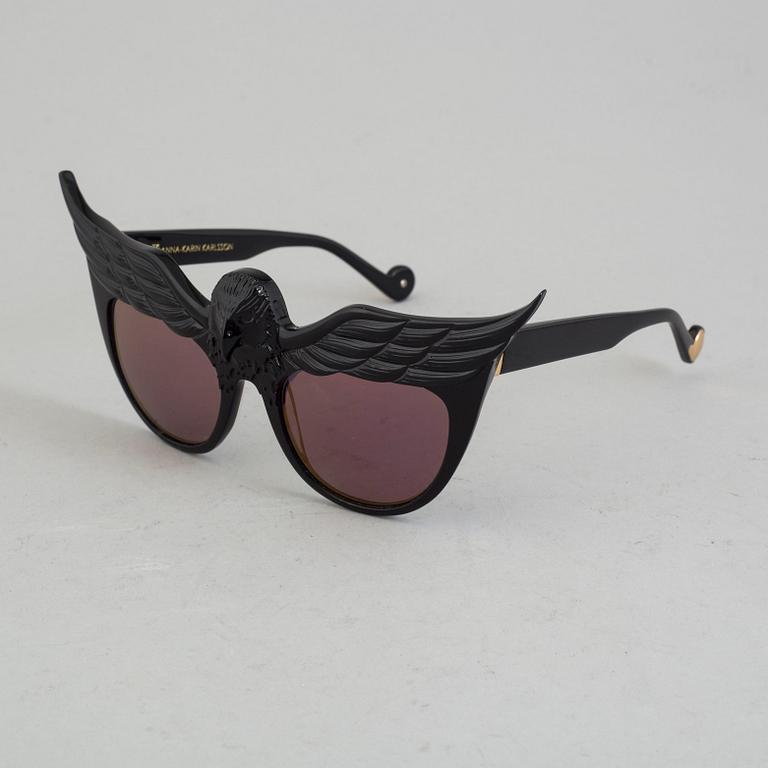 A pair of Anna-Karin Karlsson sunglasses.