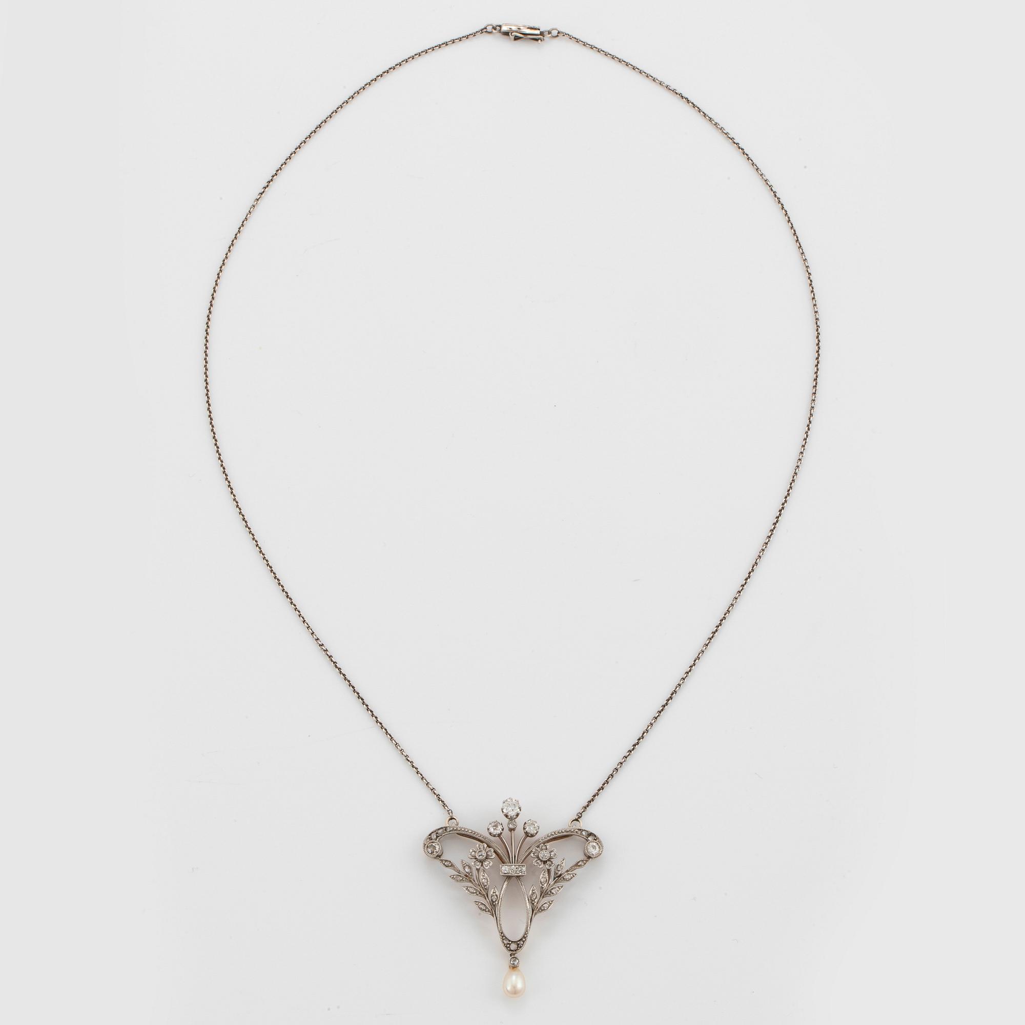 A pendant/brooch in 14K gold and platinum set with old- and rose-cut diamonds and a pearl.