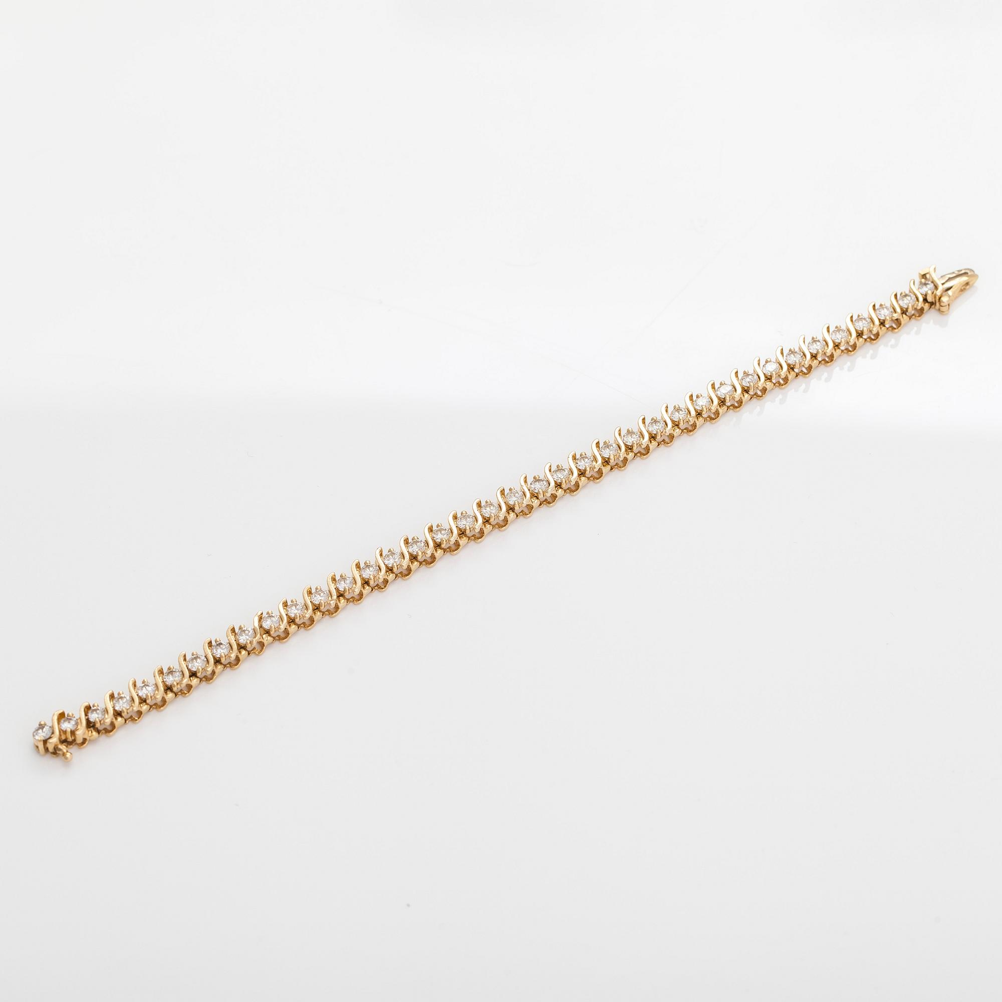 A 14K gold tennis bracelet, with brilliant-cut diamonds.
