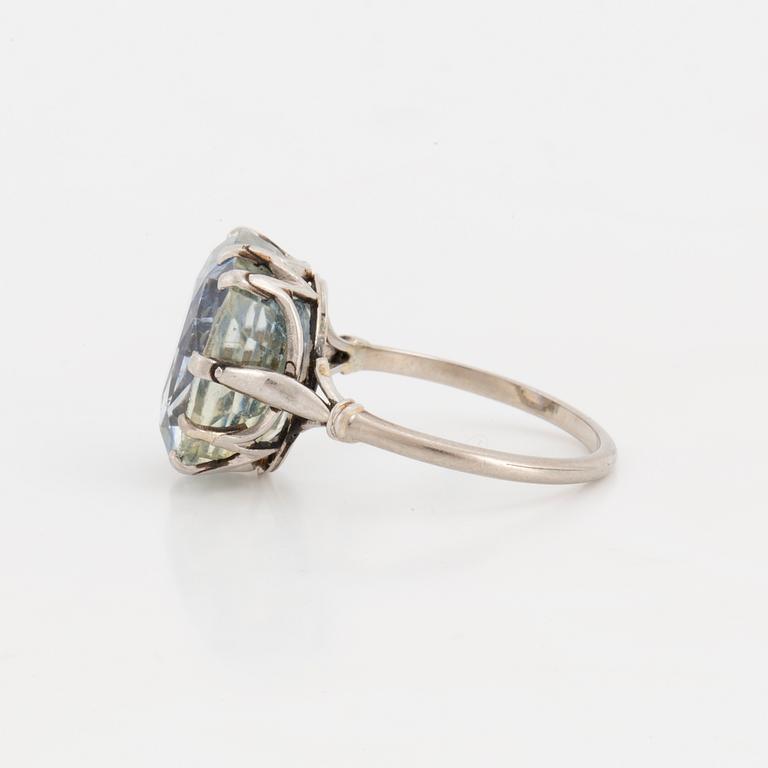 A ring set with a light blue, cushion-cut sapphire.