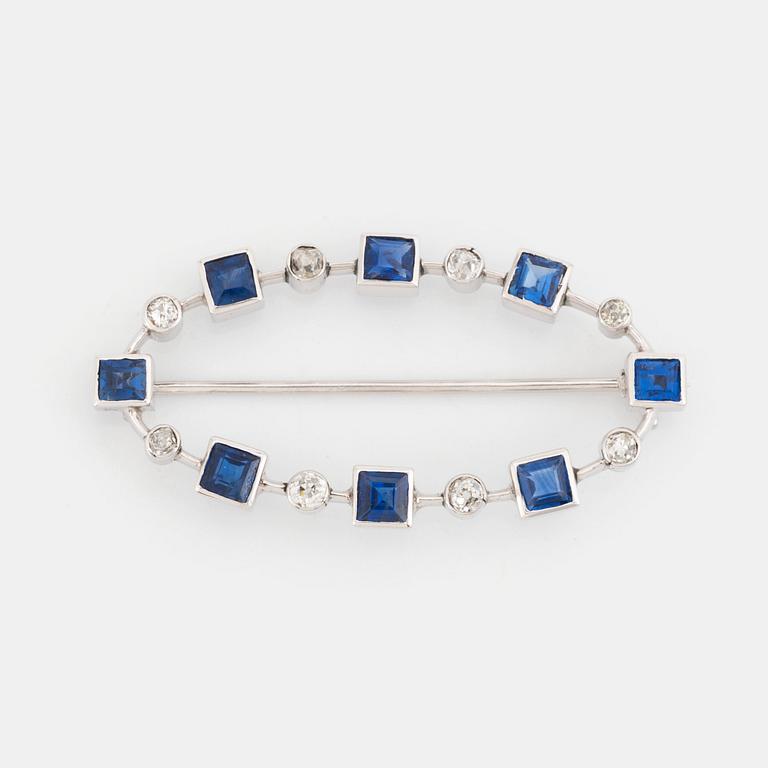 An 18K gold brooch set with faceted sapphires and old-cut diamonds.