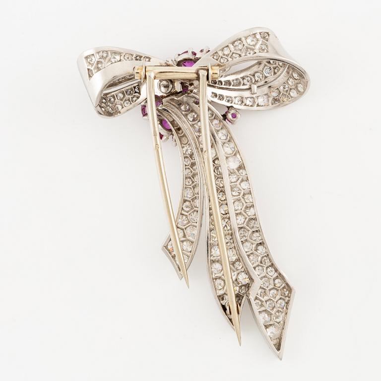 A brooch in platinum in the form of a bow with rubies and diamonds, likely from the 1950s.