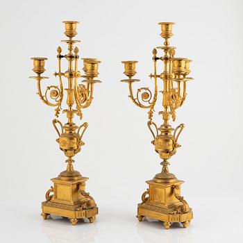 A table clock and a pair of candelabras, Louis XVI-style, France, beginning of the 20th century.