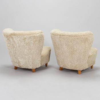A pair of mid-20th century armchairs in sheepskin.