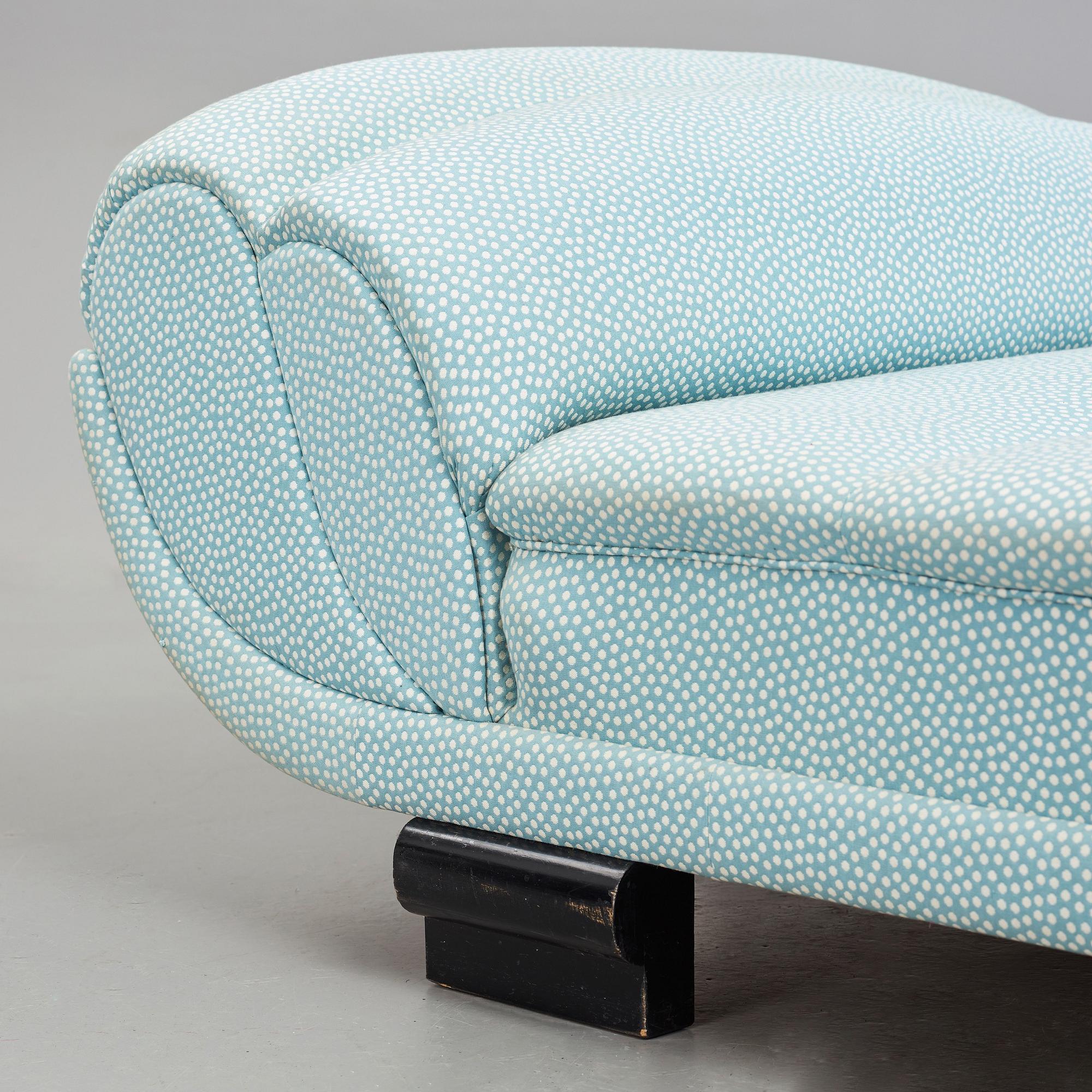 ART DÉCO, an upholstered daybed on shaped black lacquered wooden legs, 1920's-30's.