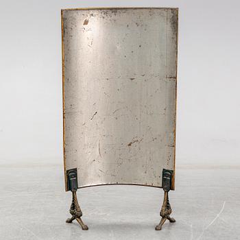 A 19th century brass fire shield decorated with paint of hunting dog setter in the stable.
