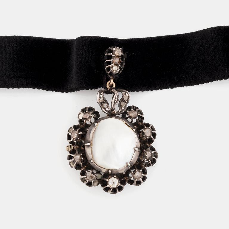 A silver pendant with a pearl and rose-cut diamonds.