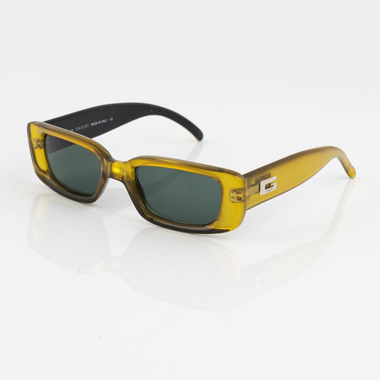 Gucci, a pair of yellow sunglasses.