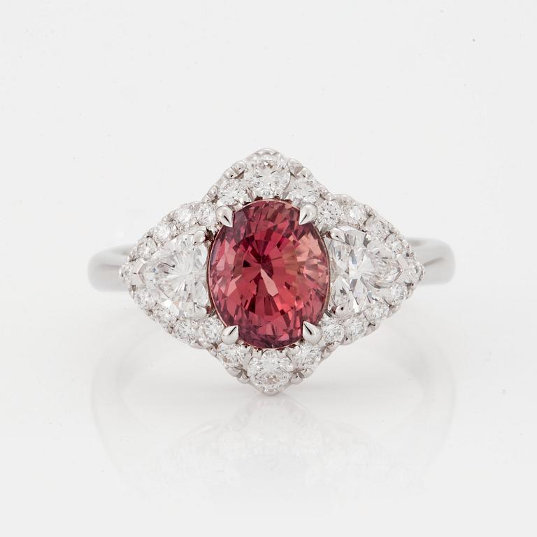 A RING set with an oval brilliant-cut padparadscha sapphire.