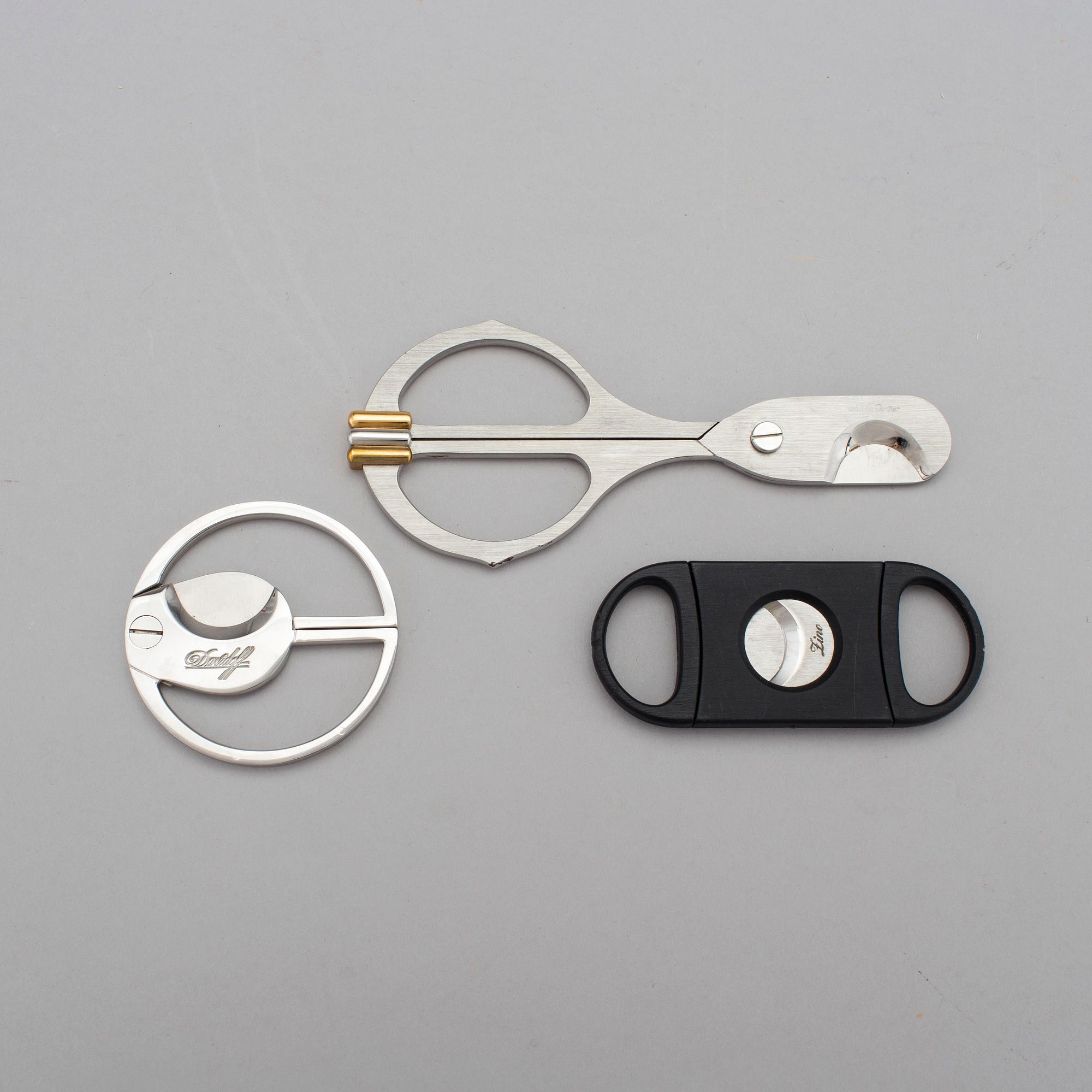 Two cigar cutters from Davidoff and must de Cartier in original cases.