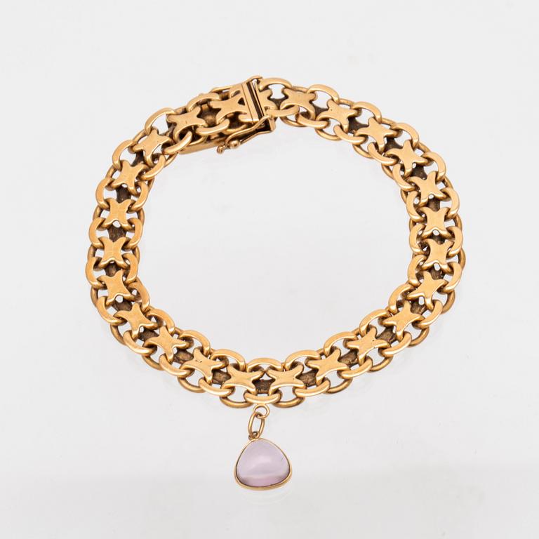 An 18K gold x-link bracelet with cabochon cut amethyst.