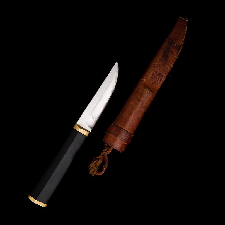 A Finnish puukko knife in stainless steel, nylon and brass designed by Tapio Wirkkala, Hackman Finland.