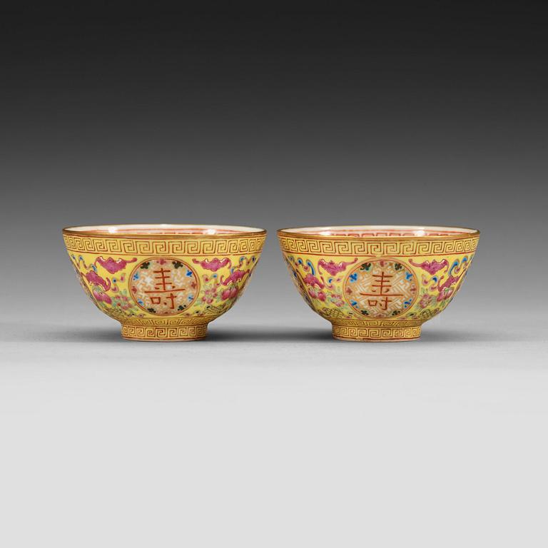 A pair of famille rose yellow ground cups, Qing dynasty, Guangxu six-character mark and of the period  (1875-1908).