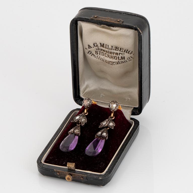 A pair of 14K gold and silver earrings set with faceted amethysts and rose-cut diamonds.