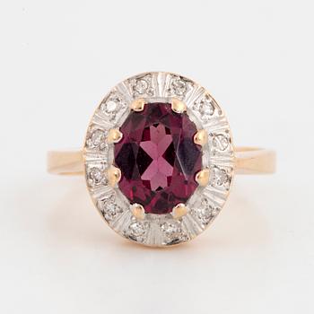 A 14K gold ring set with a garnet and eight-cut diamonds.