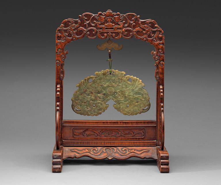 A pale spinach nephrite chime-stone with wooden stand, Qing dynasty, presumably 19th Century.