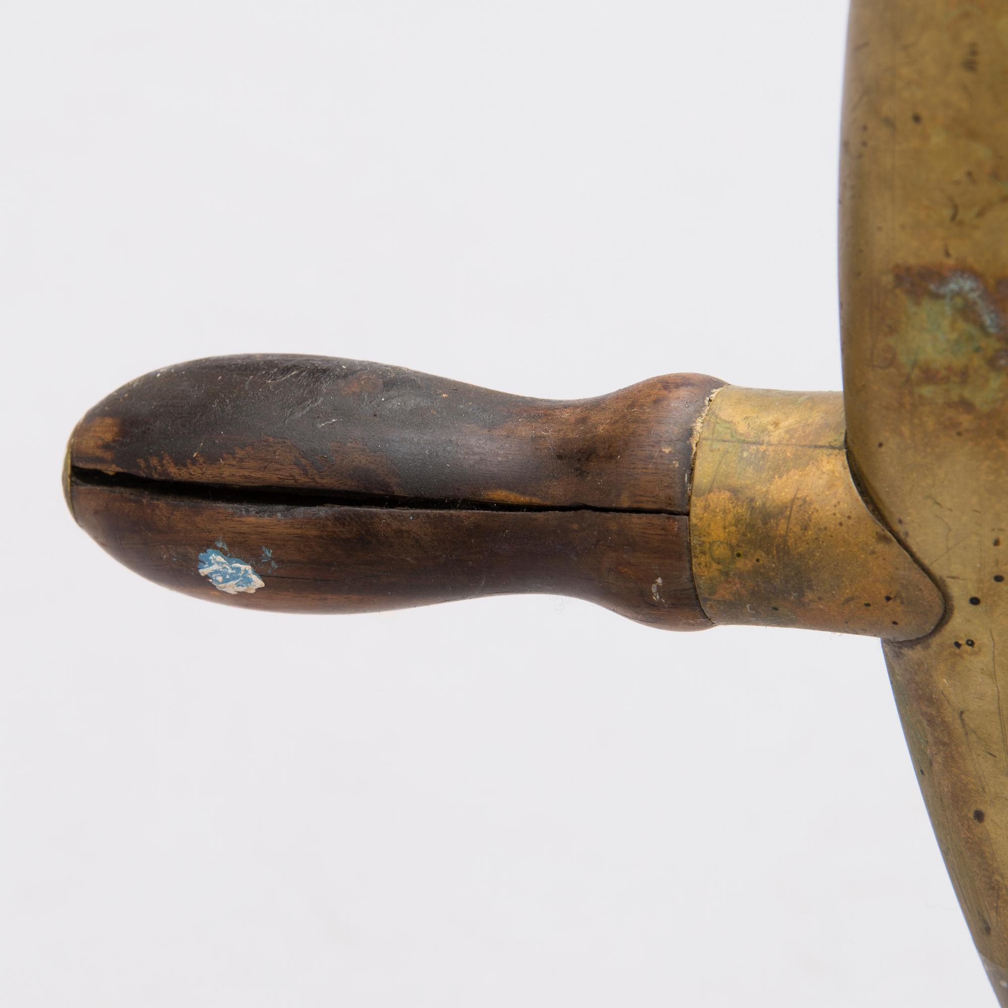 A ship's brass steering wheel, circa 1900.