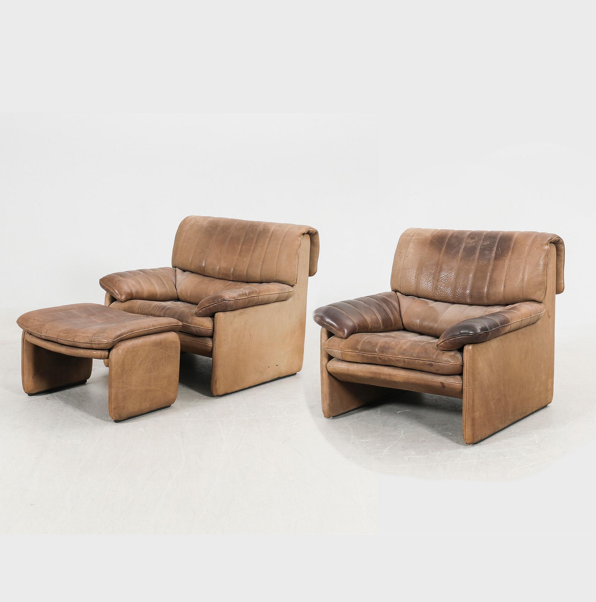 A set of two leather armchairs and a stool by De Sede, Schweiz second half of the 20th century.