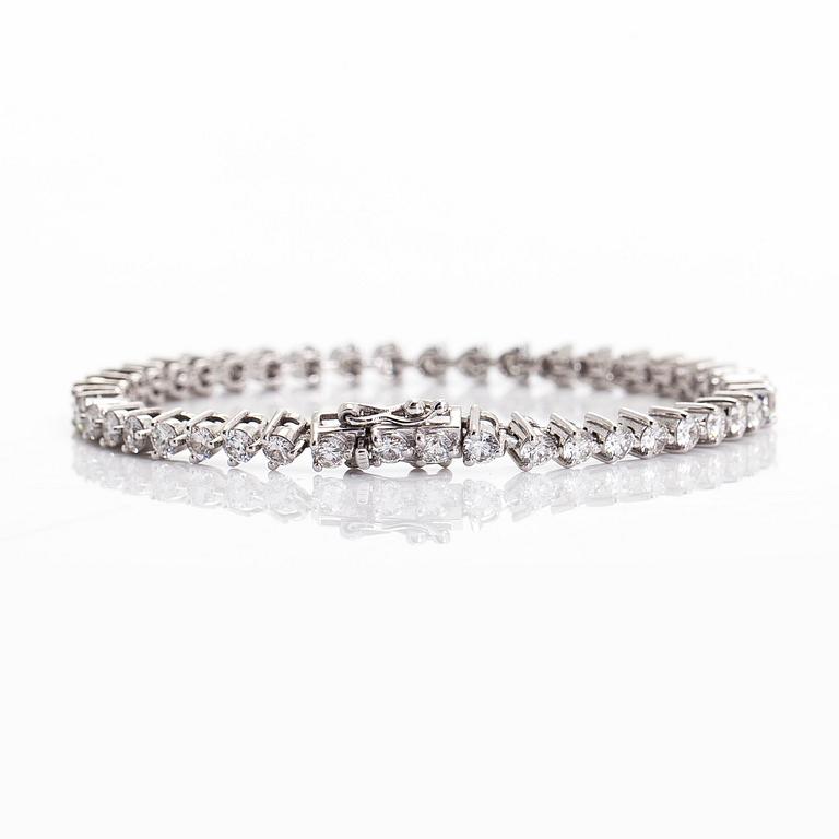 An 18K white gold tennis bracelet, with brilliant-cut diamonds.