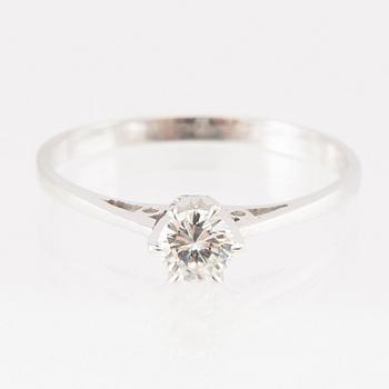 An 18K white gold solitaire ring set with a round brilliant-cut diamond.