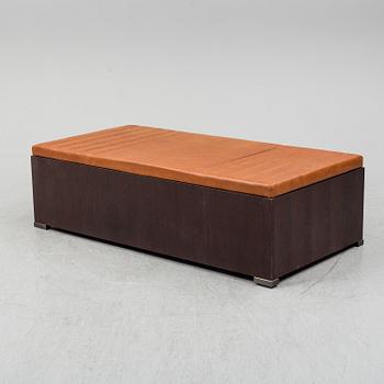 A contemporary bench with drawers and leather upholstery.