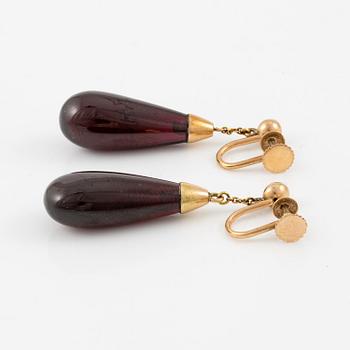A pair of 14K gold earrings with garnet drops.