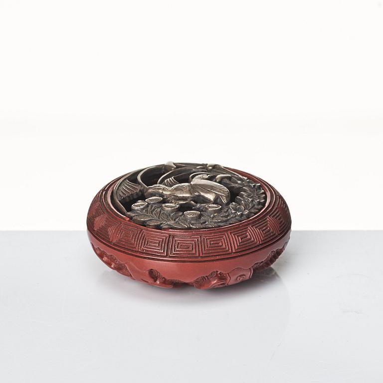 A carved red lacquer Tsuishu and metalwork Kagamibuta Netuske and a box with cover, Japan, 19th Century.