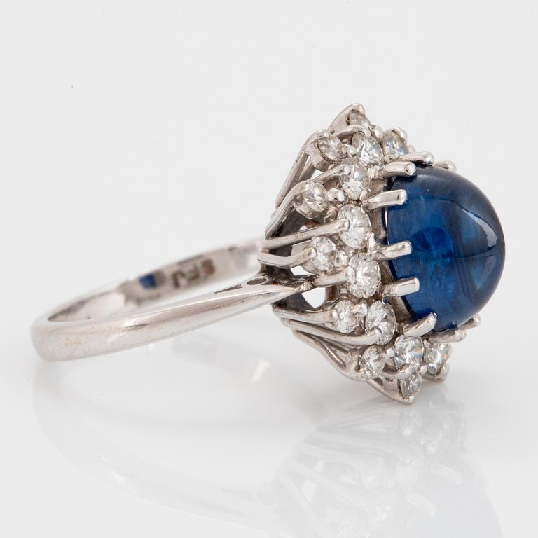 An 18K white gold ring set with a cabochon-cut sapphire ca 4.00 cts and round brilliant-cut diamonds.