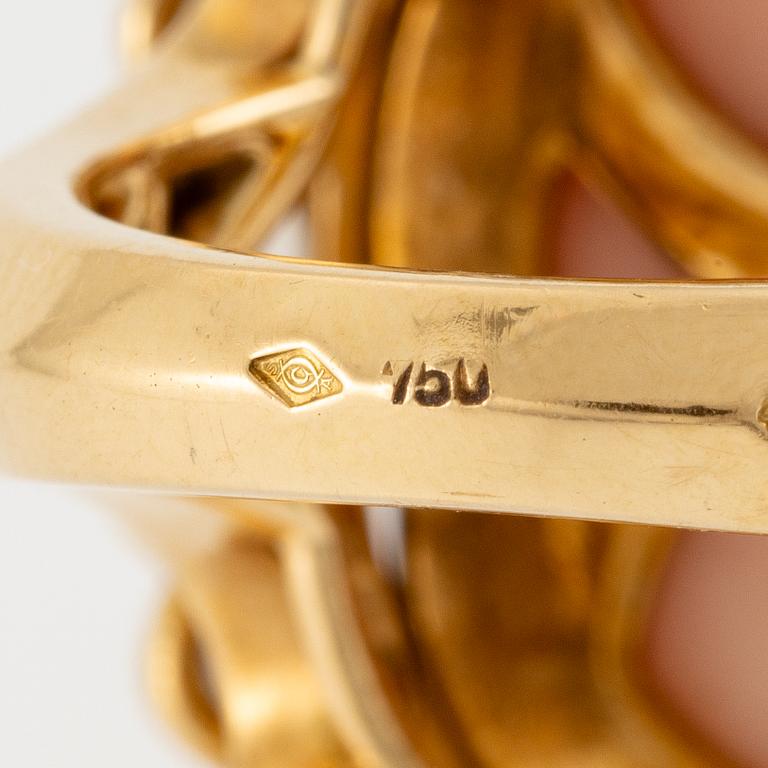 An 18K gold and coral Cartier ring set with round brilliant-cut diamonds.