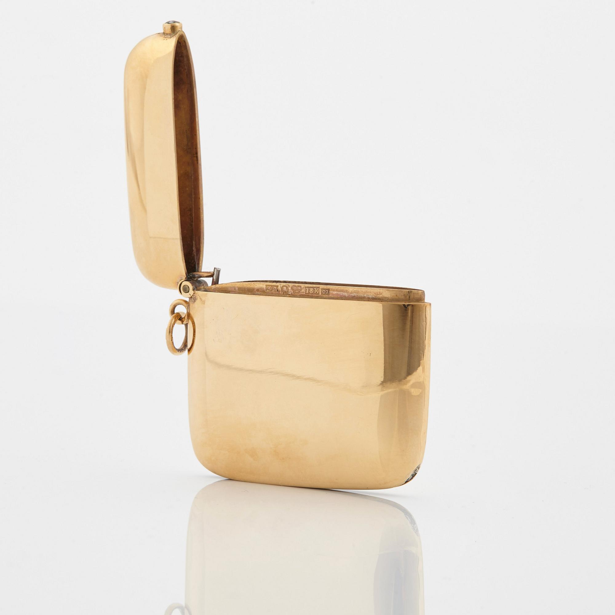 An 18K gold match case/pendant set with a faceted sapphire.