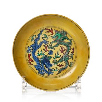 882. A Yellow glazed five clawed dragon dish, late Qing dynasty with Kangxi character mark.