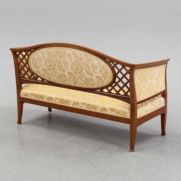 A mahogany sofa, with two armchairs and a round table, early 20th Century.