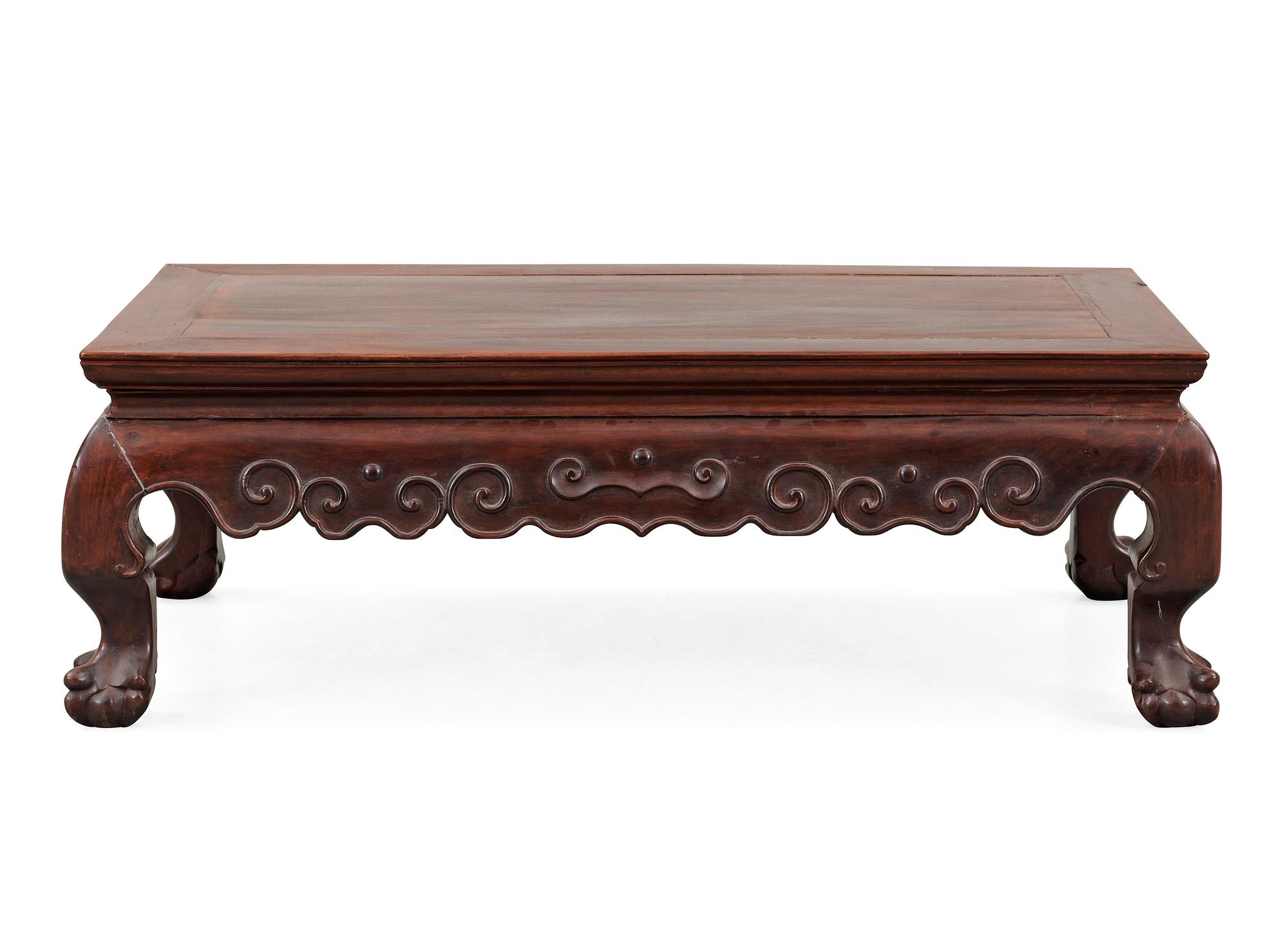 A hardwood 'claw on ball' low table, Qing dynasty.