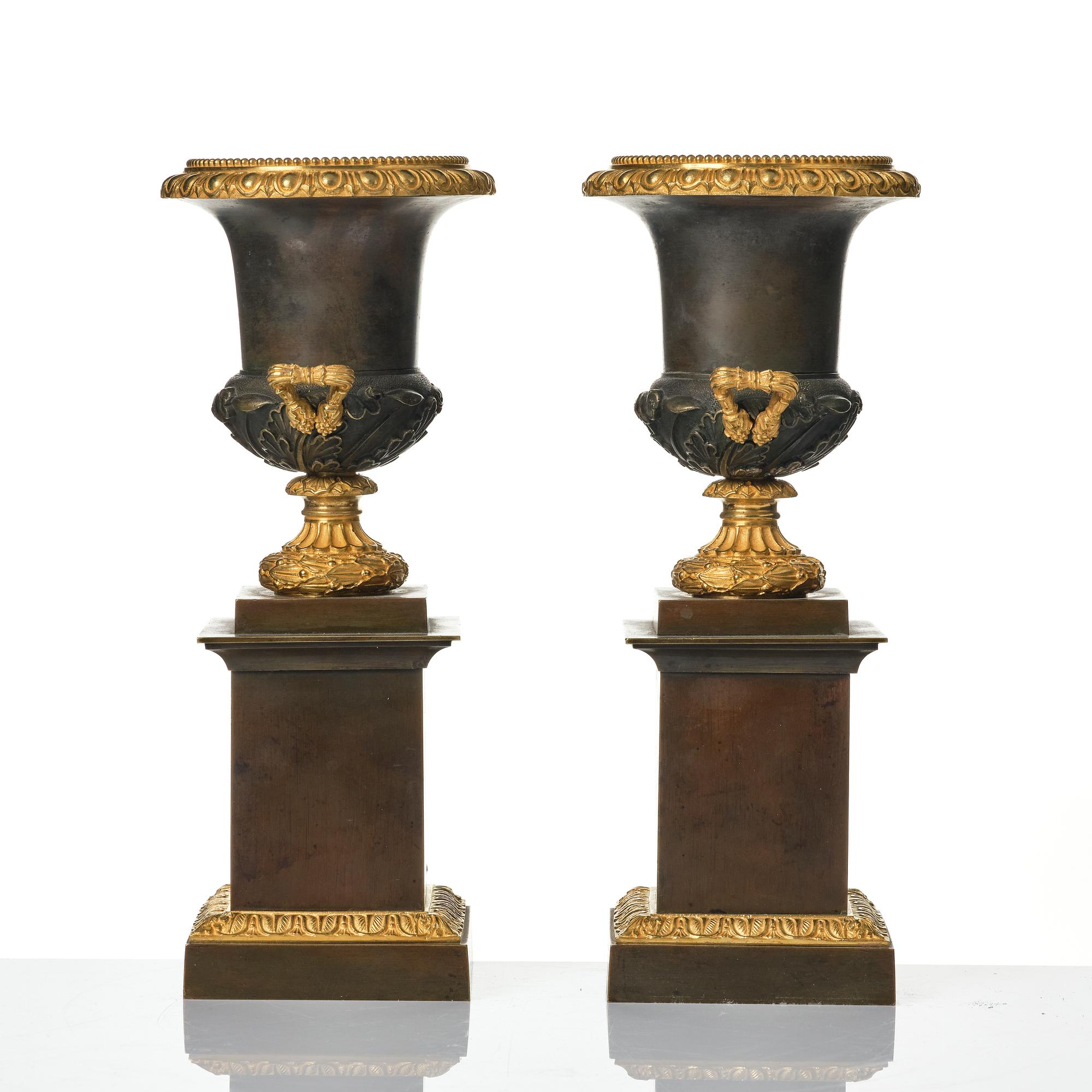 A pair of French Louis Philippe gilt and patinated bronze urns, first part 19th century.