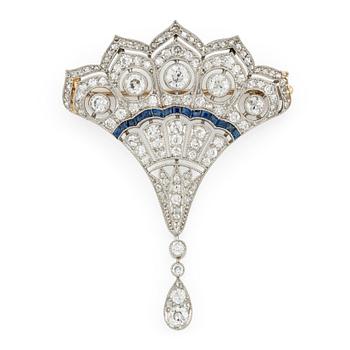 A platinum brooch with round brilliant, eight-, and rose-cut diamonds and calibré-cut sapphires.