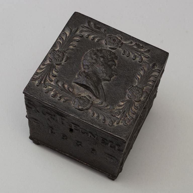 An empire cast iron tobacco box, dated 1838.