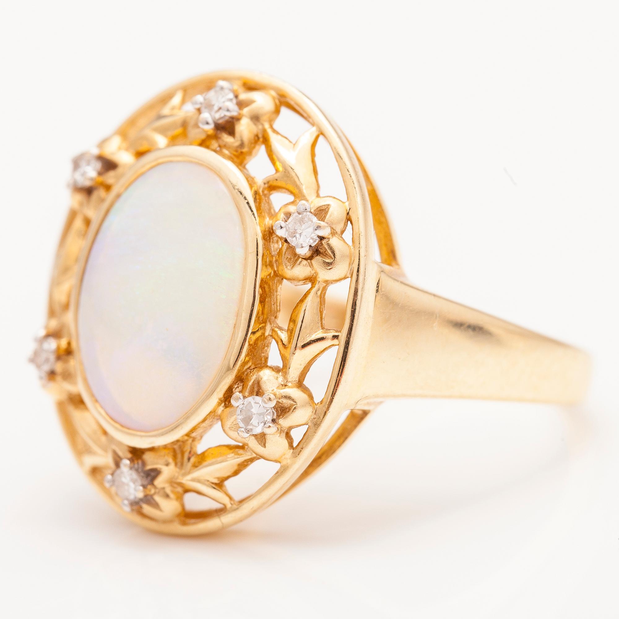 A 14K gold ring with an opal and diamonds ca. 0.12 ct in total.