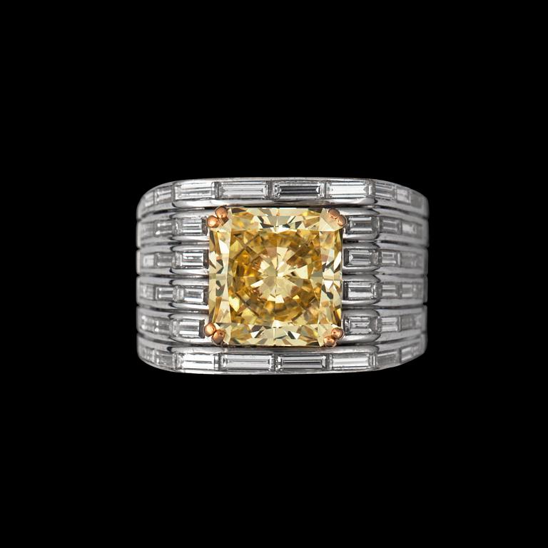 A fancy yellow diamond ring, according to certificate 4.13 cts, and 52 tapered baguette-cut diamonds tot. 1.69 cts.