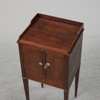 A first half of the 19th century mahogany veneered bedside table.