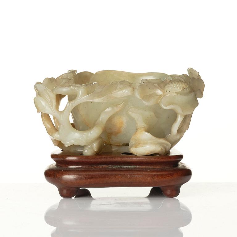 A carved Chinese nephrite cup in the shape of a lotus leaf, late Ming dynasty.