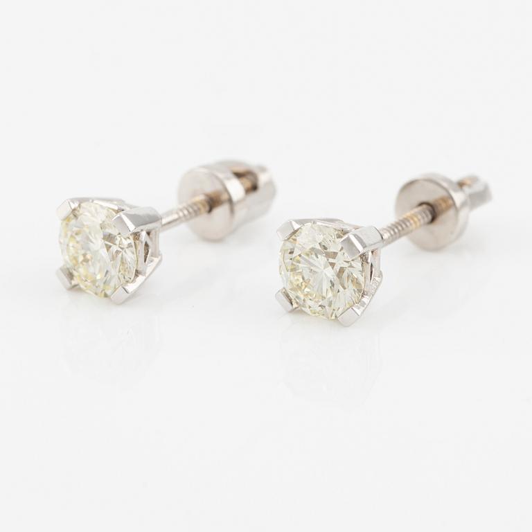 A pair of 18K gold earrings with round brilliant-cut diamonds.