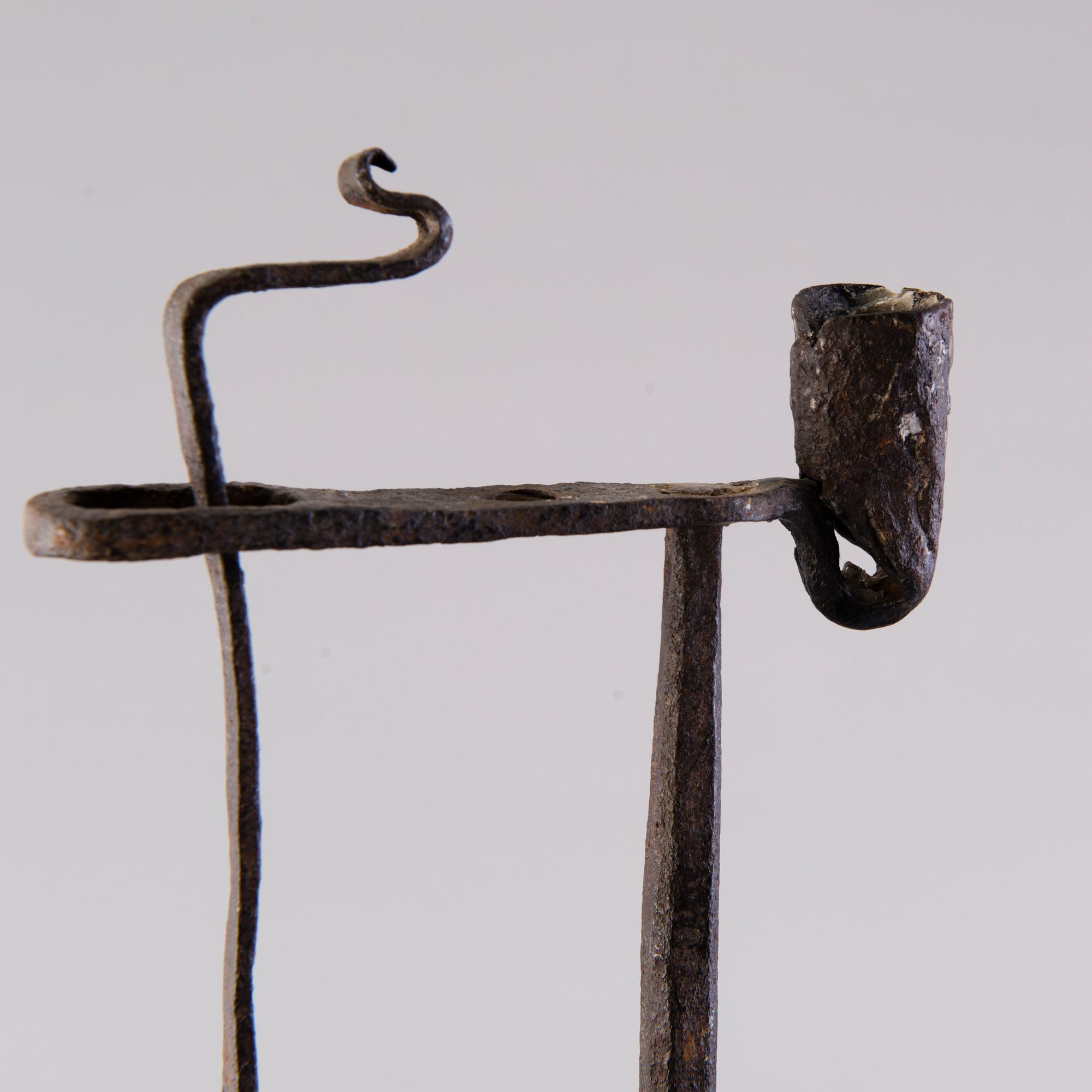 A 18th century wrought iron rush light and candle holder.