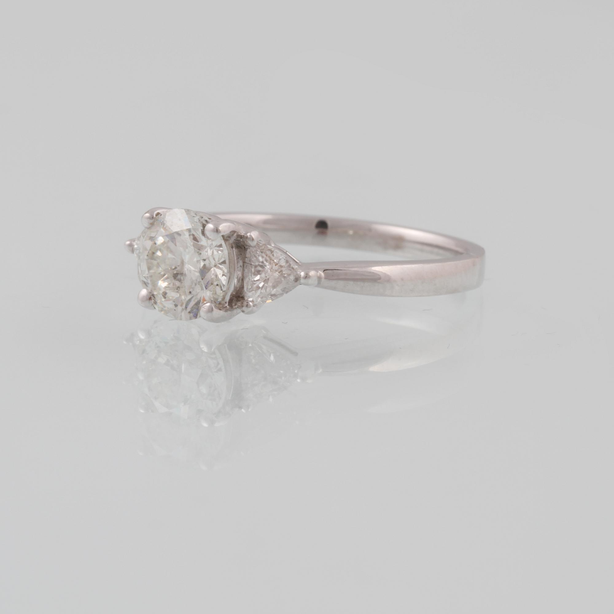 RING, 18K vitguld med briljantslipad diamant ca 1.02 ct samt 2 triangelslipade diamanter ca 0.31 ct. Vikt 3,2 gram.