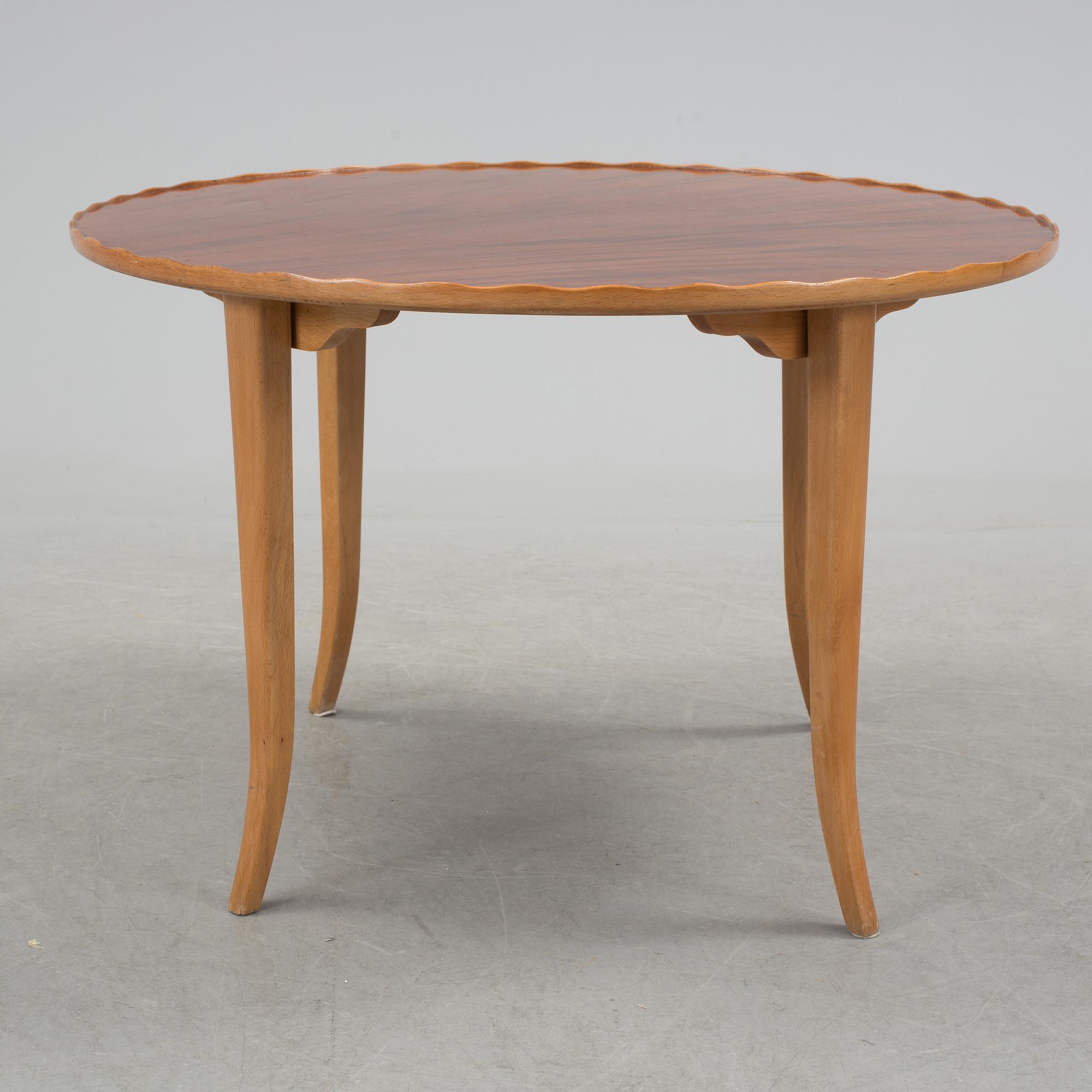 A mid 20th century coffee table in beech and veneered with mahogany.