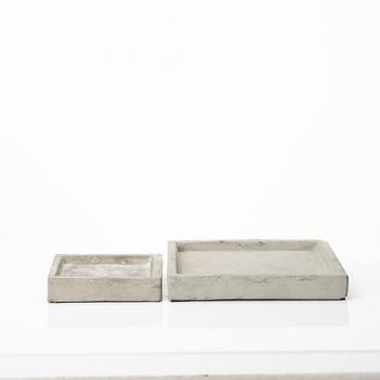 A mixed lot comprising a pair of limestone bookends, a bookshelf and two plates in concrete.