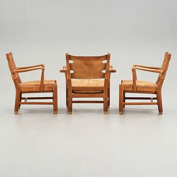 SCANDINAVIAN MODERN, a set of three mid 20th century mahogany and brown leather easy chairs.